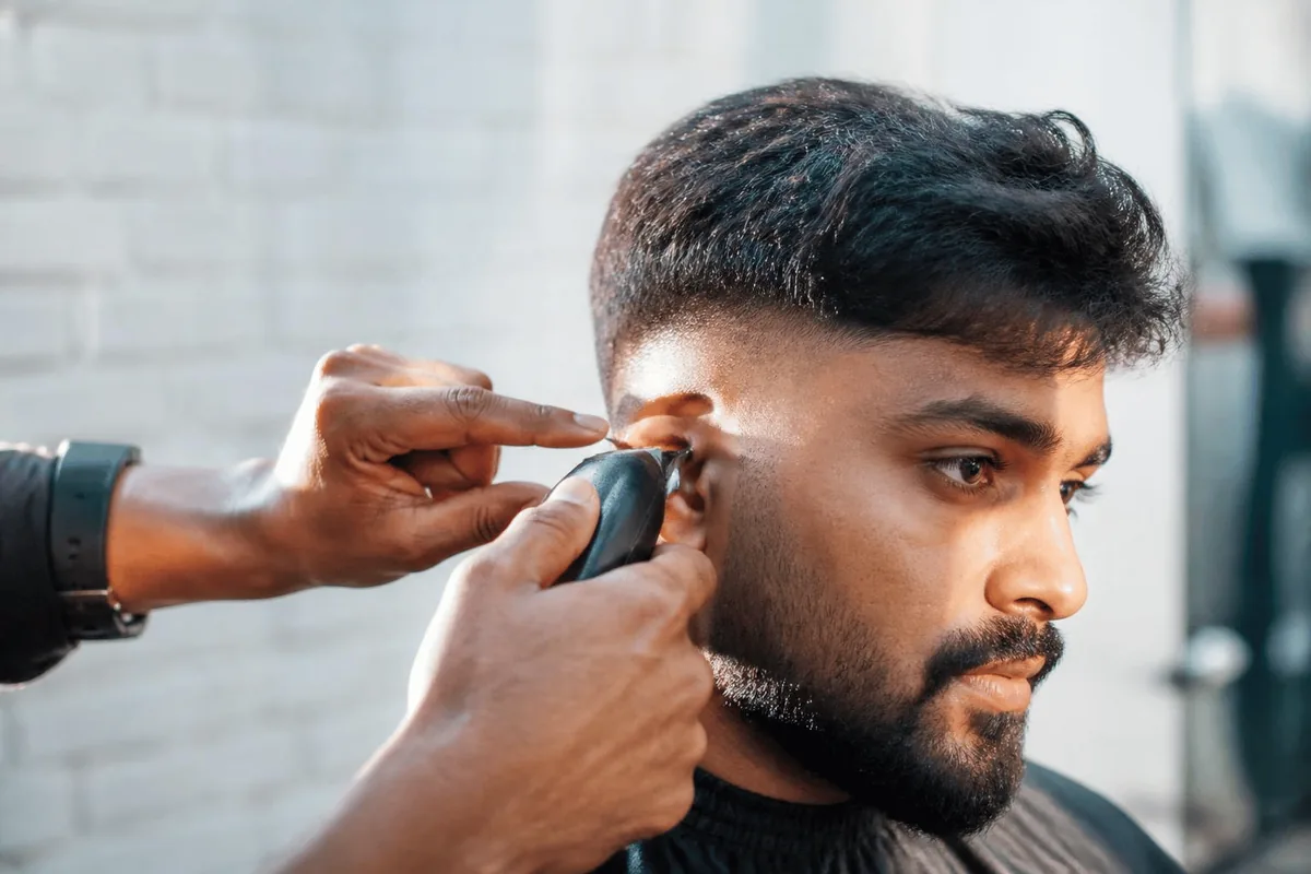 Cutting mid drop fade trimmer around ear