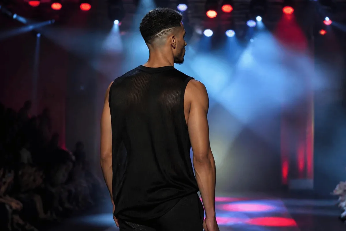 Small geometric pattern shaved into a low taper fade, back view of a runway model